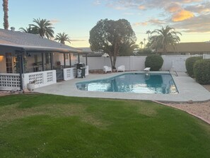 A backyard with a swimming pool, a covered patio, and a fenced area with outdoor furniture. - Walk or Bike to Old Town Scottsdale in a Quiet, Clean & Contemporary Sanctuary (Scottsdale)