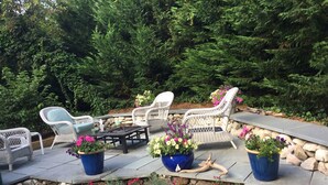 An outdoor patio area with stone steps, wicker furniture, and potted plants. - Pochet Association - Nauset Beach Access - Central Air (2161) (Orleans)