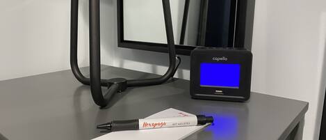 A desk with a pen, a notepad, and a device displaying 'capello' on a blue screen.