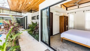 A modern bedroom with a large bed, sliding glass doors, and a wooden ceiling. - Flow - Casita, For Love Of Waves (Nosara)