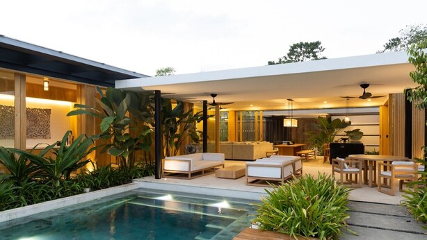 A modern outdoor pool area with a wooden deck, lounge seating, and a dining area. - Nai'a, Private entrance to Beach, Gated Comunity (Nosara)