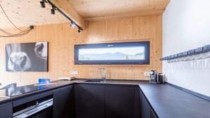 A modern kitchen with a wooden ceiling, a large window, a built-in oven, and a wine rack. - Superior Chalet at Kreischberg (Sankt Georgen am Kreischberg)