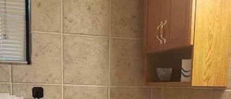 A bathroom with a toilet, a sink, and a cabinet.