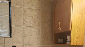 A bathroom with a toilet, a sink, and wooden cabinets. - Private Room W/Deck**MiniFridge&Microwave (Kingsland)