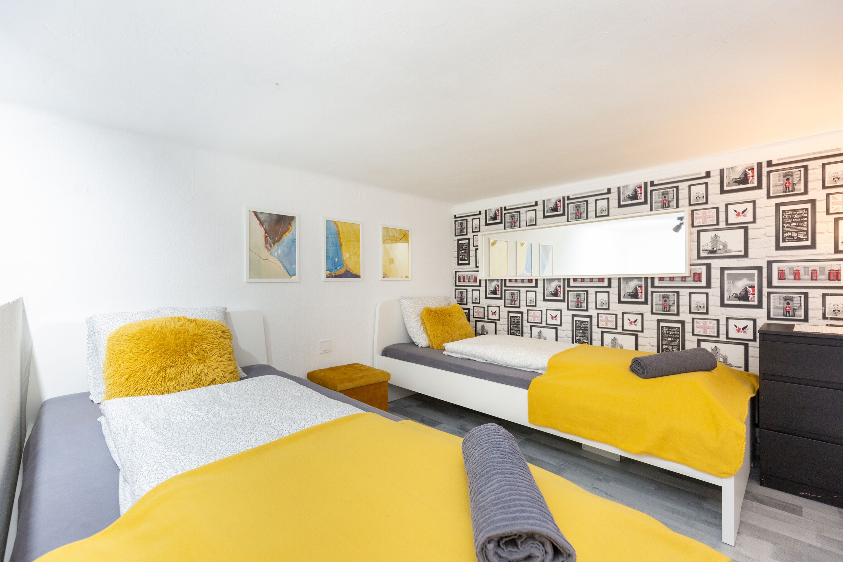A hotel room with a bed, a sofa, a small table, and a wardrobe.