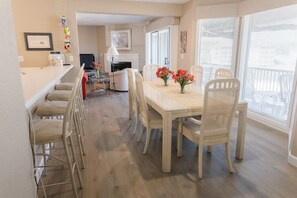 Een eethoek met een tafel, stoelen en een open haard.