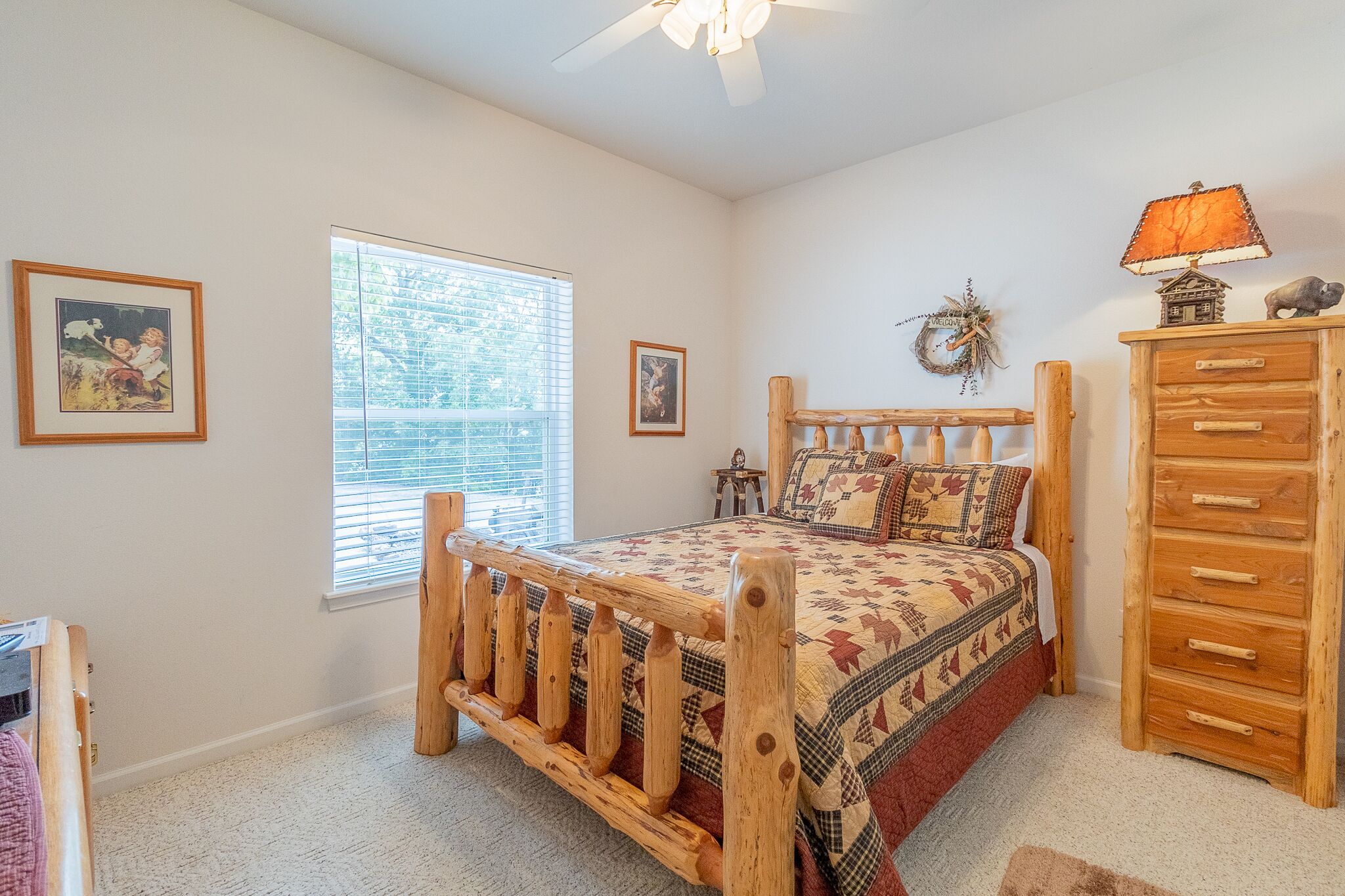 A bedroom with a wooden bed, a dresser, and a window with blinds.
