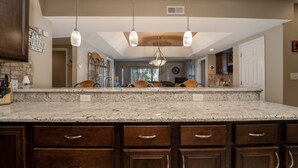 A kitchen with a large island, dark wooden cabinets, and pendant lighting. - Falls 90 - Beautiful 3 Bdrm Falls Condo (Lake Ozark)