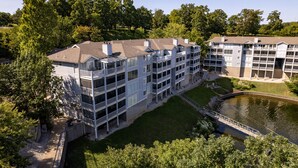 A multi-story hotel with balconies, a courtyard, and a lake view. - Regatta Bay 488 - Walk In 3 Bdrm Condo (Village of Four Seasons)