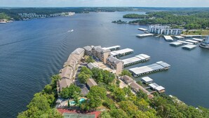A waterfront property with multiple buildings, docks, and a tennis court. - Falls 118 - 4 Bdrm condo with Breathtaking View (Lake Ozark)