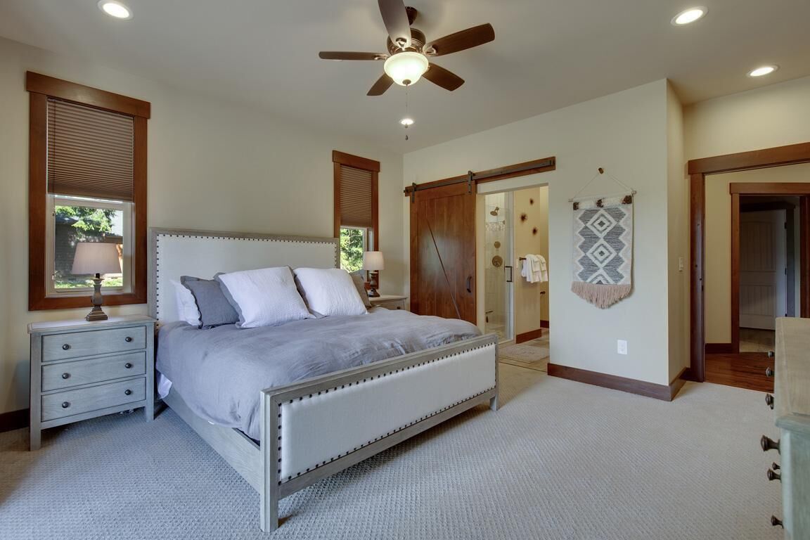 Ein Schlafzimmer mit Bett, Nachttisch und Deckenventilator.