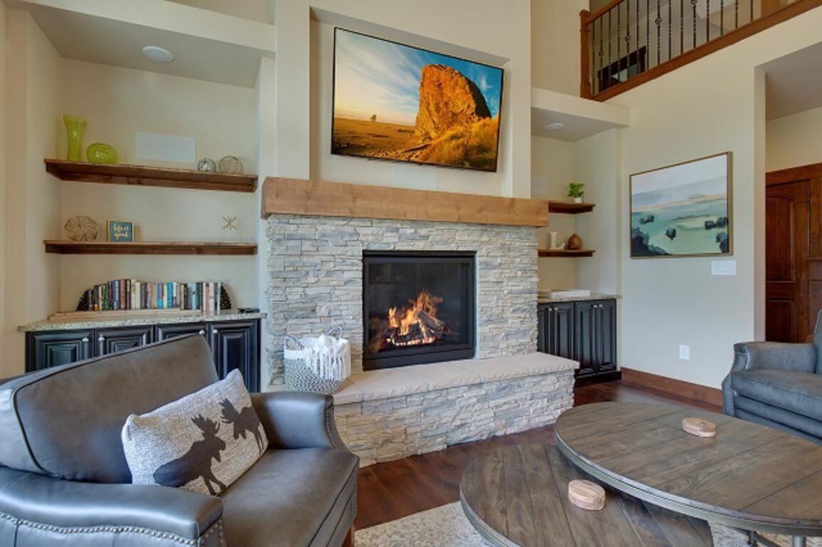 Una sala de estar con chimenea de piedra, sofás de cuero y una mesa de centro.