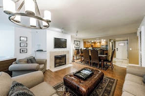 Cozy living room with a fireplace, flat-screen TV, and dining area.