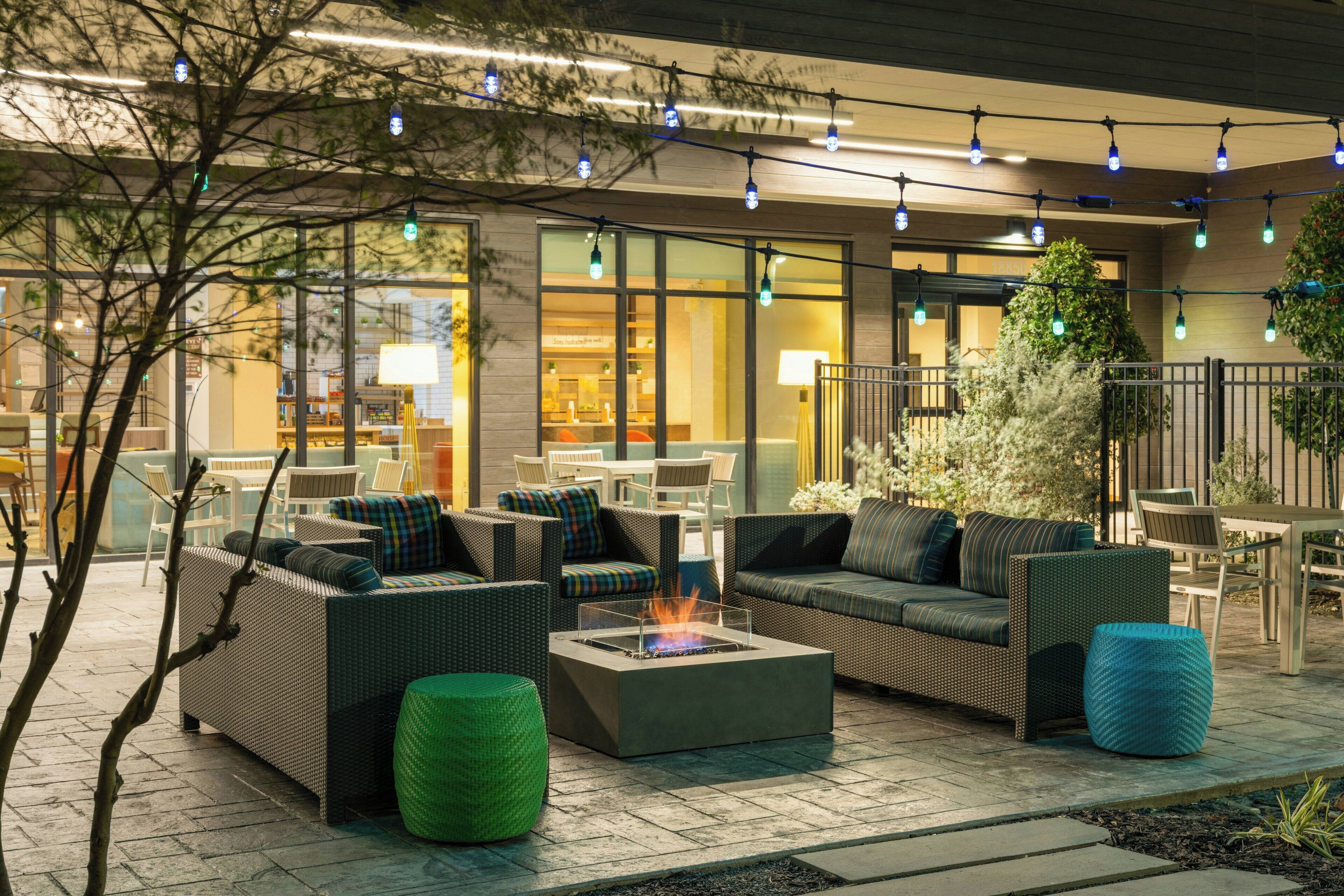 An outdoor seating area with wicker furniture and a fire pit.