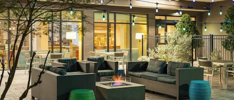 Un espace extérieur aménagé avec des meubles en osier et un foyer.