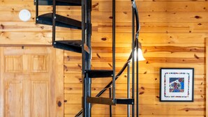 Eine Wendeltreppe in einem Holzambiente mit einem gerahmten Bild an der Wand.