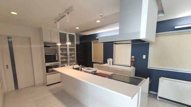 A modern kitchen with a central island, built-in cabinets, and a microwave.
