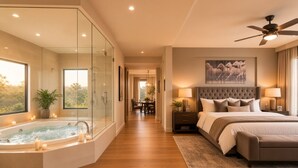 A modern bedroom with a large bed, a glass-enclosed jacuzzi, and a view of the outdoors.