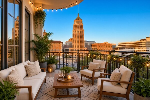 A balcony with a sofa set, a wooden table, and string lights.