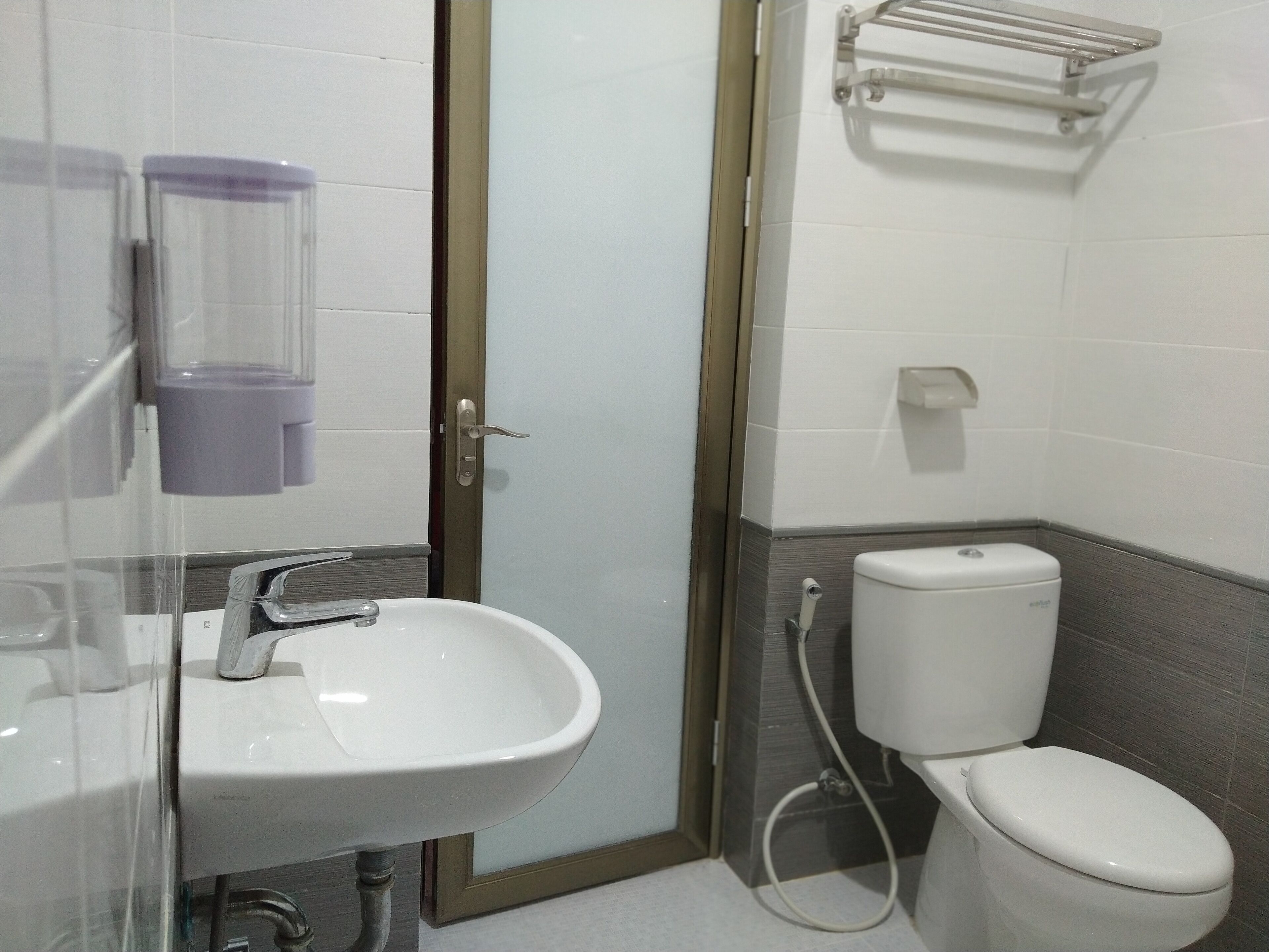 Un baño con lavamanos blanco, inodoro y zona de ducha.