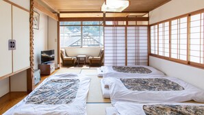 Um quarto japonês tradicional com piso de tatame, uma mesa baixa e portas deslizantes.
