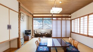 Um quarto japonês tradicional com tatames, uma mesa baixa e almofadas.