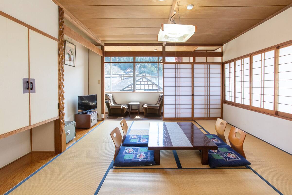 Et traditionelt japansk rum med tatamimåtter, et lavt bord og puder.