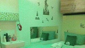 A bedroom with a bed, a nightstand, a mirror, a sink, and a cabinet. - Ferienwohnung) (Wien)