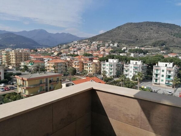 Un barrio residencial con edificios de varios pisos, una montaña al fondo y un cielo despejado.