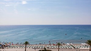 Ein Strand mit Sonnenschirmen und Personen.