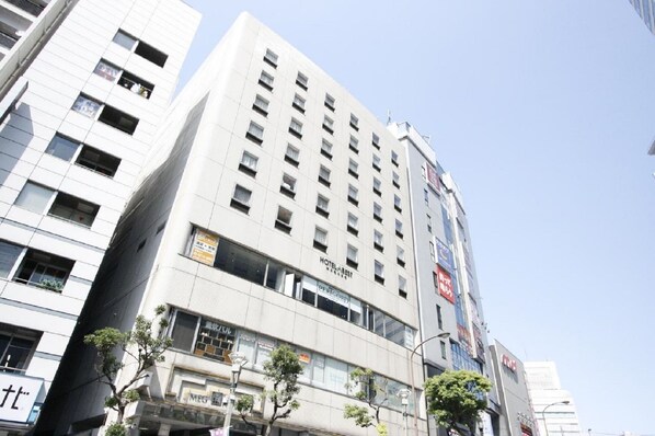 A multi-story hotel with a modern facade, multiple windows, and signage for 'Hotel Best' and 'Hotel Best' in English.