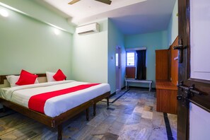 A bedroom with a bed, a wooden bench, and a wardrobe. - OYO 49253 Raja Residency (Hyderabad)