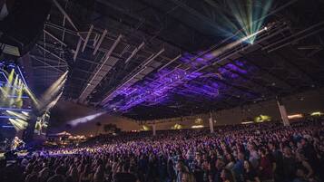 A large indoor venue with a high ceiling and a crowd of people.