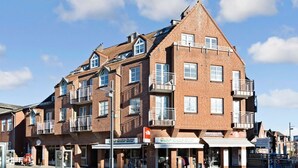 A multi-story brick building with balconies and storefronts. - Beach, shopping, relaxing - all very close by (Sylt)