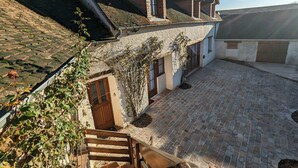 Ein traditionelles Haus mit Innenhof, Steinmauern und einem Ziegeldach.