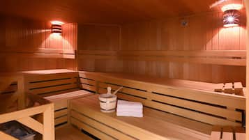 A wooden sauna with benches, a wooden bucket with a ladle, and a towel.