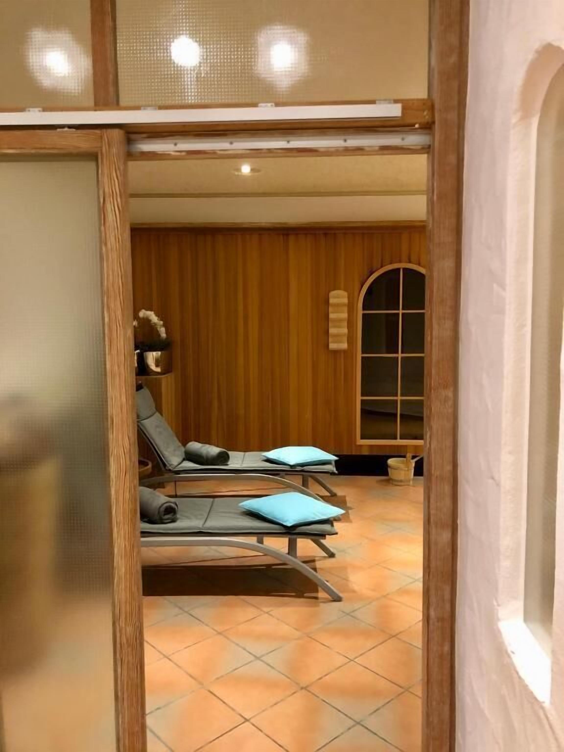 Una habitación con dos sillones reclinables, una pared de madera y piso de baldosas.