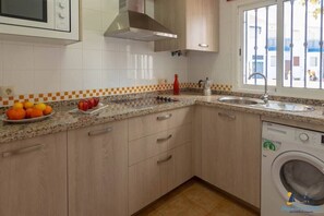 Enjoy cooking in this well-equipped kitchen with a range hood, microwave, and dishwasher.