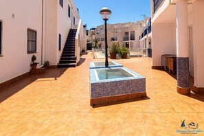 Relax in the serene courtyard, surrounded by lush greenery and a glass-topped table for al fresco dining.