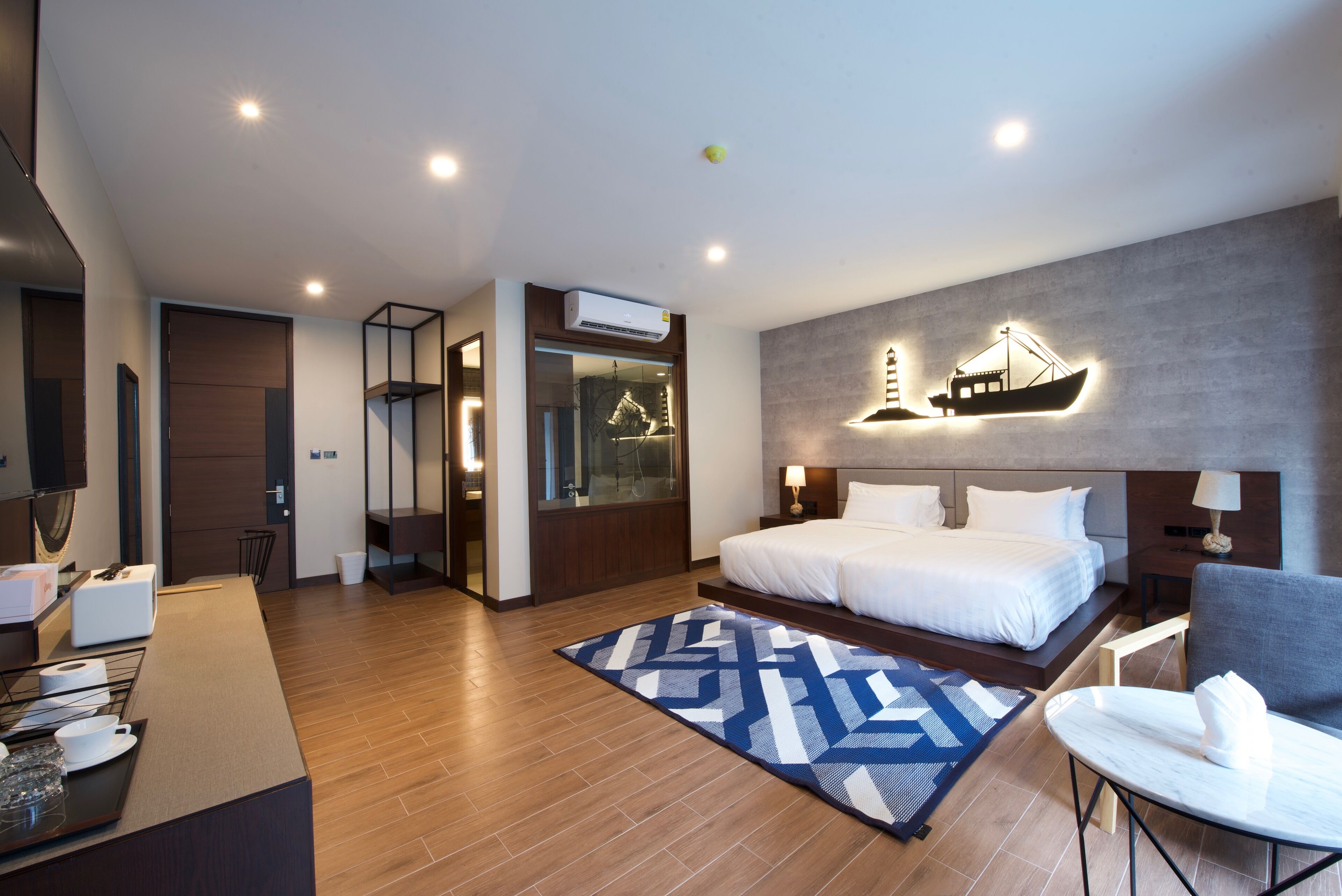 A modern hotel room with a large bed, a desk, and a bathroom.