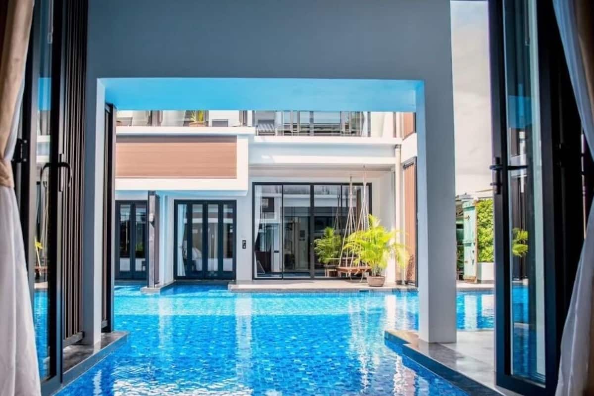 Vue d’un espace piscine avec un bâtiment moderne en arrière-plan.