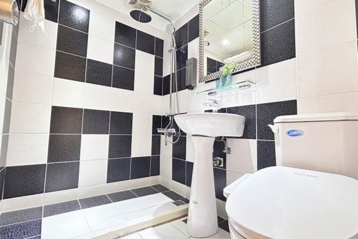 Un baño con lavamanos blanco, inodoro y zona de ducha.