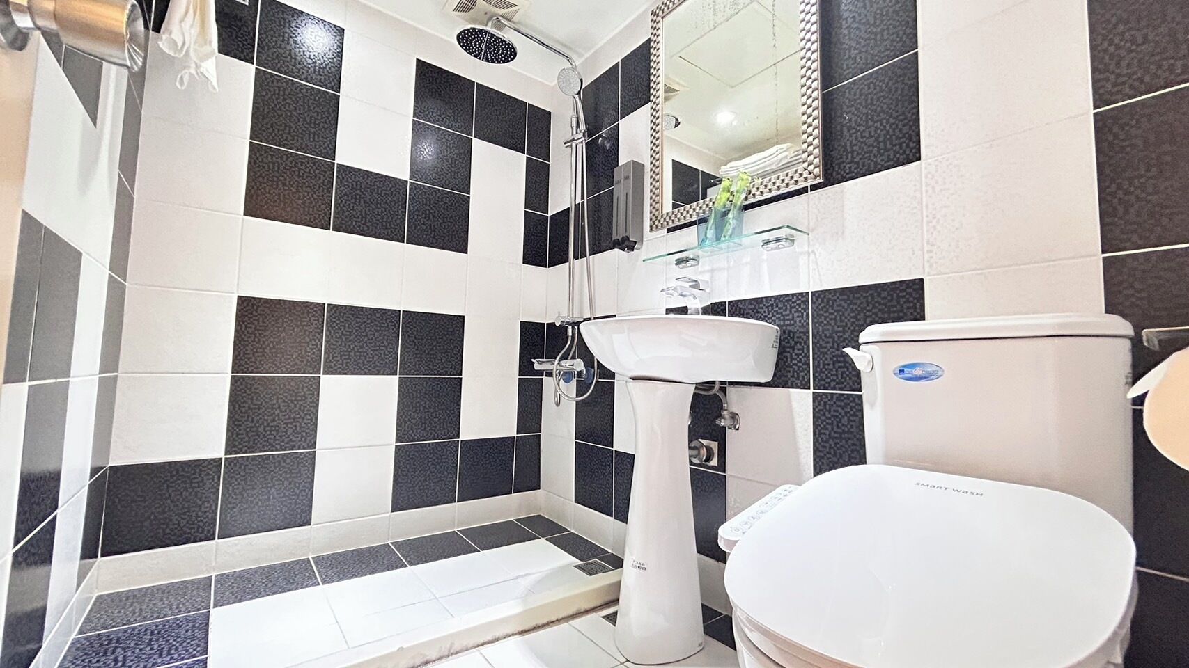 A bathroom with a white toilet, a sink, and a shower.