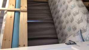 A room with a sloped ceiling, wooden beams, and a patterned curtain. - 2 bedroom Apartment  Heathrow Airport (Hayes)
