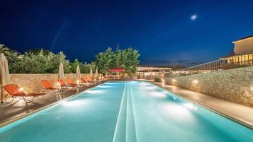 Una piscina al aire libre de temporada, sombrillas, tumbonas