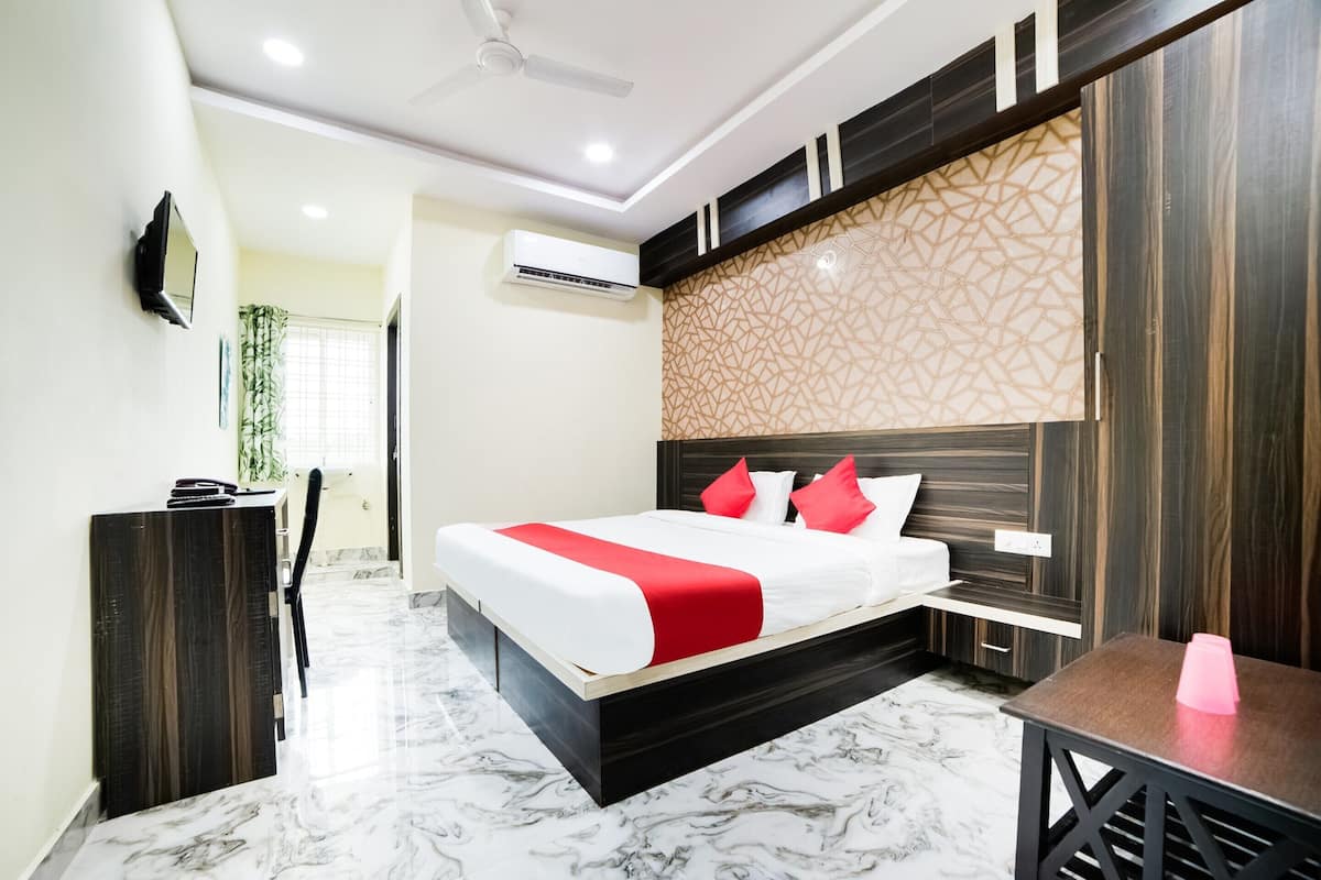Una habitación de hotel moderna con una cama grande, un escritorio y un televisor.