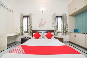 A bedroom with a bed, two nightstands, a wardrobe, and a wall-mounted air conditioner. - Gardenia Service Apartments (Hyderabad)
