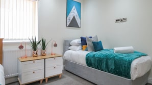 Une chambre à coucher avec un lit, une table de chevet et une fenêtre avec des stores.