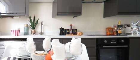 Business Townhome | Private kitchen | Full-sized fridge, microwave, oven, stovetop