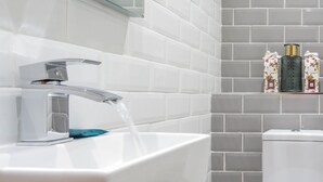 Une salle de bain avec un lavabo moderne, un robinet et des toilettes.
